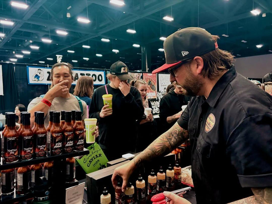 Andy Knox pouring hot sauce samples at a busy trade show